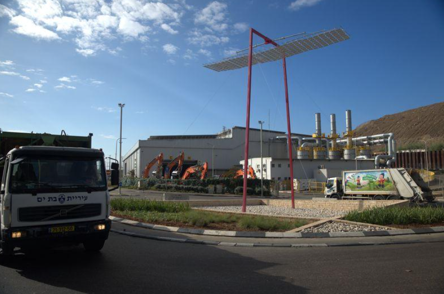 מבנה תעשייתי וגשר הולכי רגל עם אנשים בפארק המיחזור חירייה