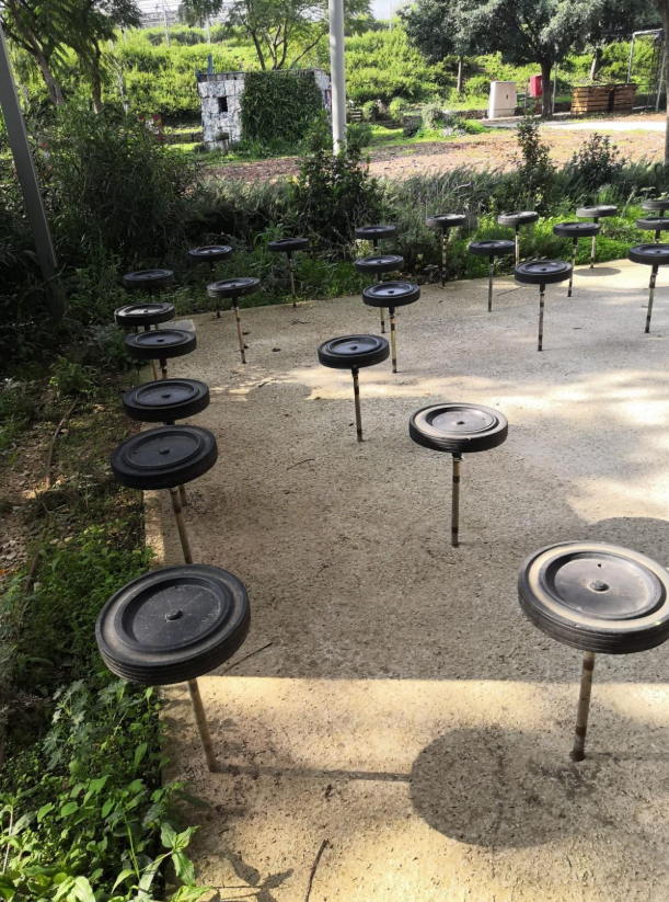 מבנה תעשייתי וגשר הולכי רגל עם אנשים בפארק המיחזור חירייה