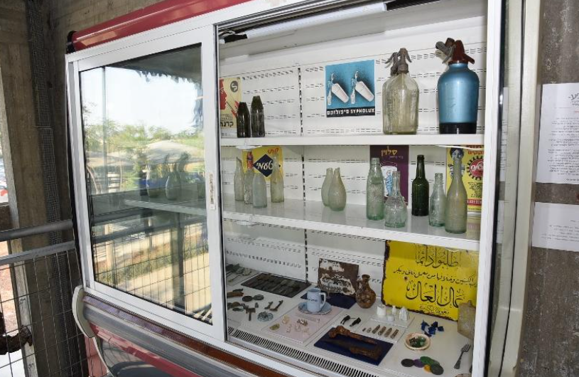 ויטרינת תצוגה הכוללת מגוון בקבוקי זכוכית וחפצים עתיקים בתערוכה.
